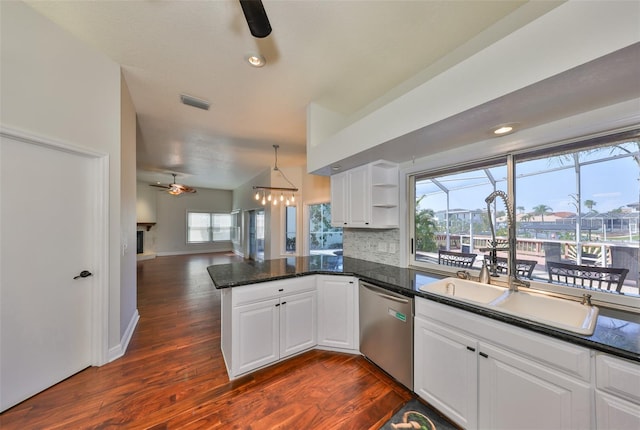 kitchen featuring decorative backsplash, open floor plan, dishwasher, a peninsula, and ceiling fan with notable chandelier