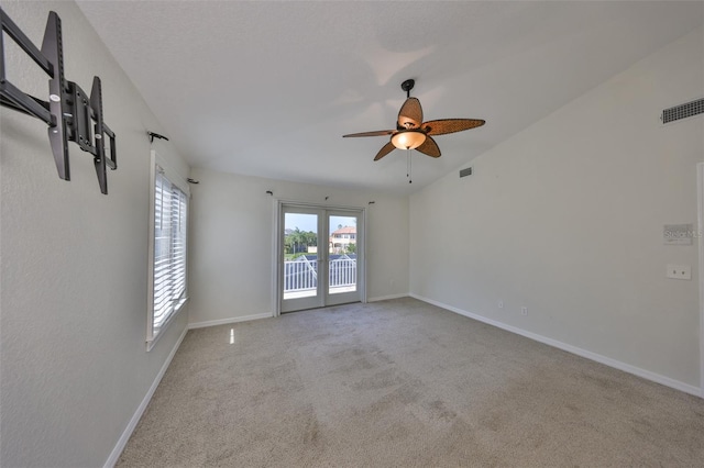 spare room with lofted ceiling, carpet floors, visible vents, and baseboards