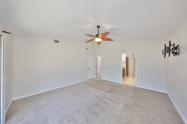 empty room featuring vaulted ceiling, baseboards, visible vents, and light colored carpet