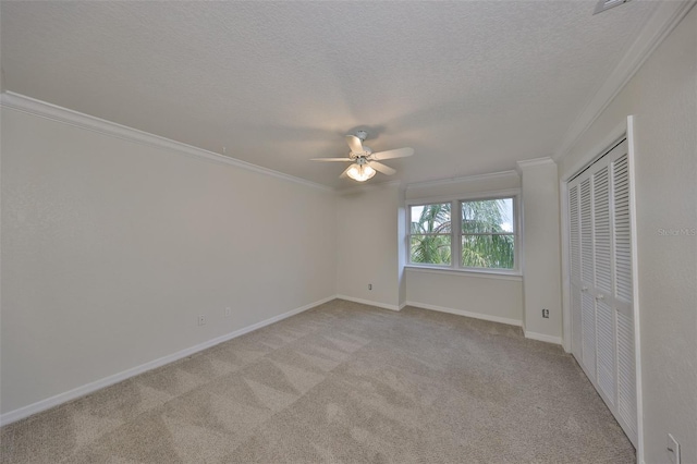 unfurnished bedroom featuring a textured ceiling, crown molding, and light colored carpet