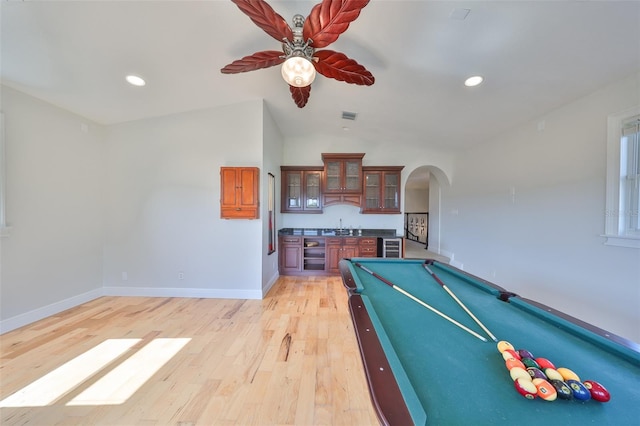 game room featuring light wood-type flooring, arched walkways, baseboards, and recessed lighting