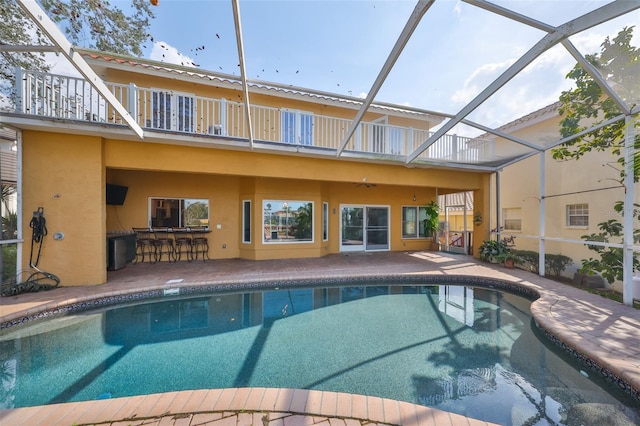 outdoor pool with a lanai, a patio area, and outdoor dry bar