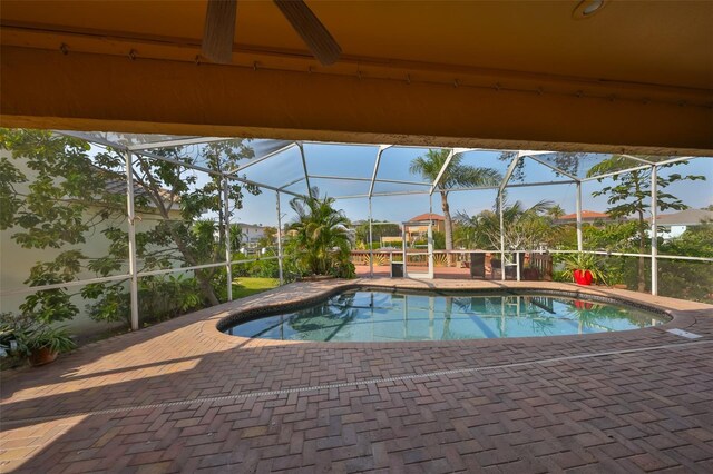 outdoor pool with glass enclosure and a patio