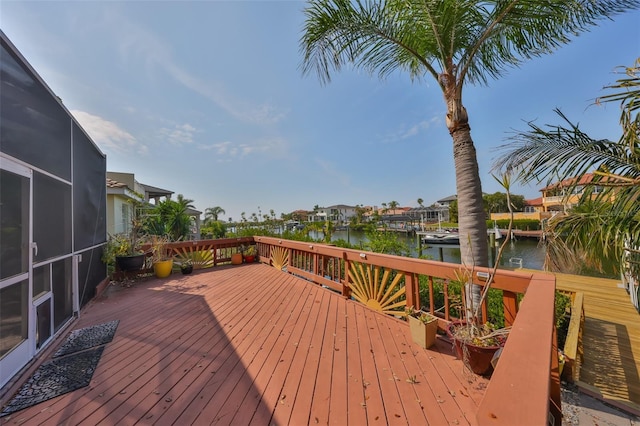 wooden terrace with a water view and glass enclosure