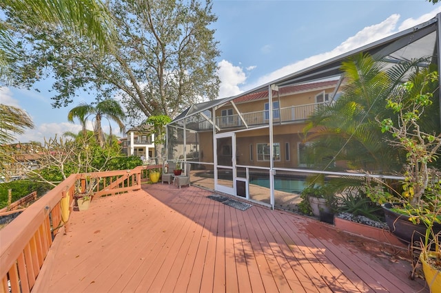 wooden deck with glass enclosure and an outdoor pool