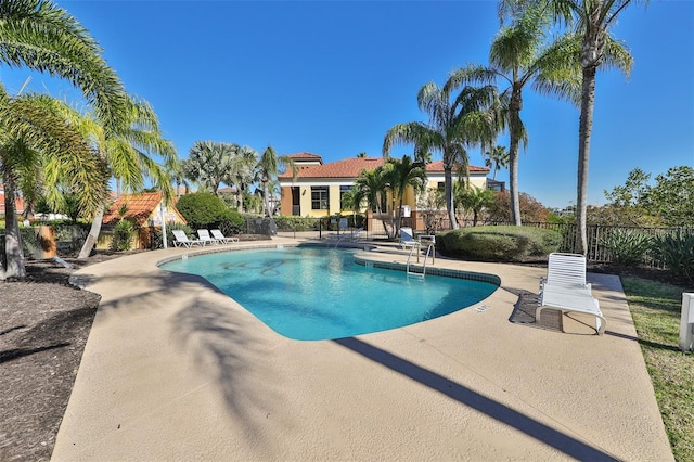 pool with a patio area and fence