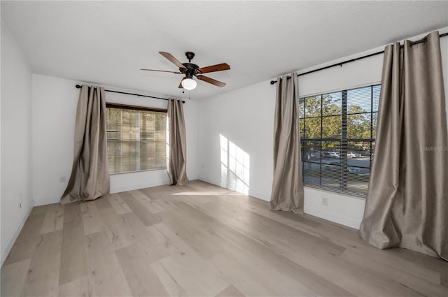 unfurnished room featuring ceiling fan, a textured ceiling, light hardwood / wood-style floors, and a healthy amount of sunlight