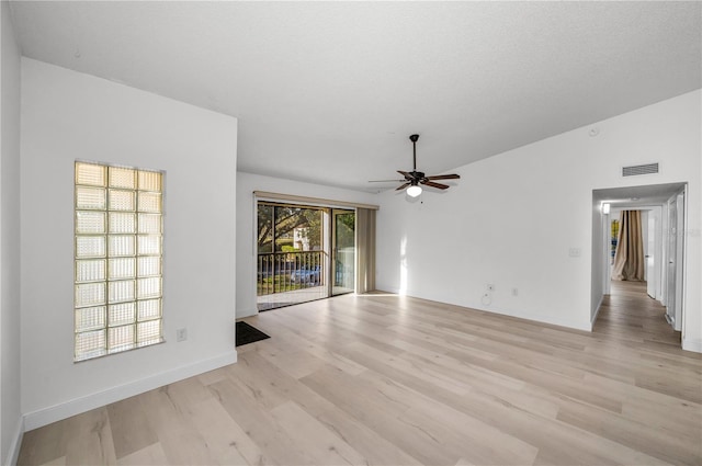 unfurnished room featuring ceiling fan, lofted ceiling, a textured ceiling, and light wood-type flooring