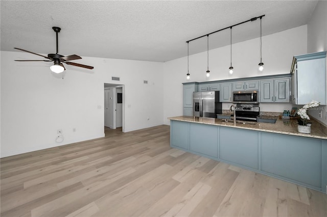 kitchen with pendant lighting, stainless steel appliances, high vaulted ceiling, light hardwood / wood-style floors, and kitchen peninsula