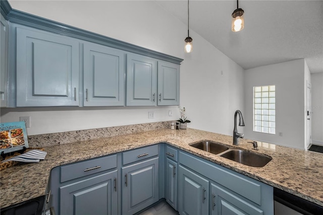 kitchen with vaulted ceiling, sink, pendant lighting, and blue cabinetry