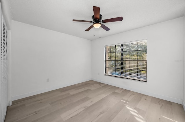 spare room with ceiling fan, light hardwood / wood-style floors, and a textured ceiling