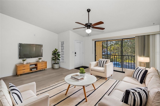 living room with vaulted ceiling, light hardwood / wood-style floors, and ceiling fan