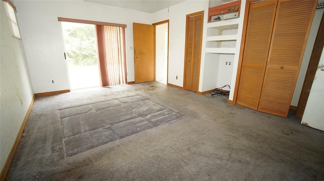 unfurnished bedroom with multiple closets and carpet floors