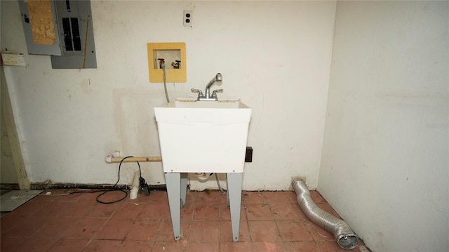 clothes washing area featuring sink, electric panel, and tile patterned floors