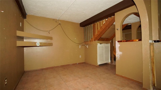 interior space with light tile patterned floors and a textured ceiling