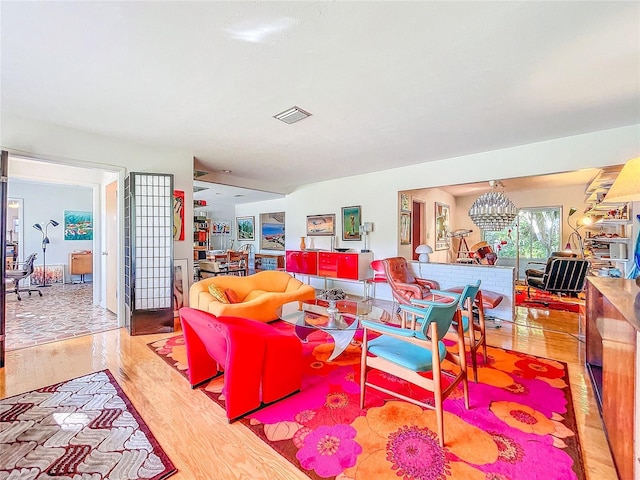 living room featuring a notable chandelier and light wood-type flooring