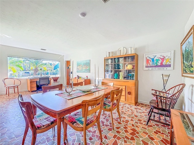 dining space featuring a textured ceiling