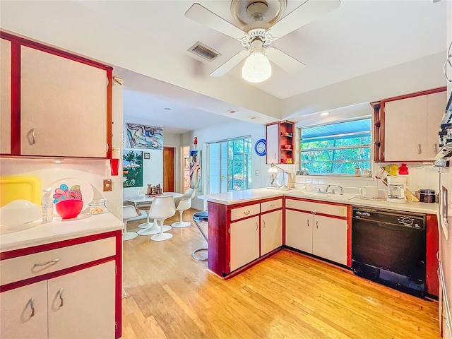 kitchen featuring sink, light wood-type flooring, black dishwasher, kitchen peninsula, and ceiling fan