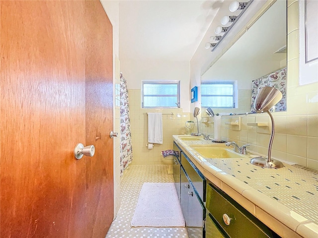 bathroom with tile walls, vanity, and toilet