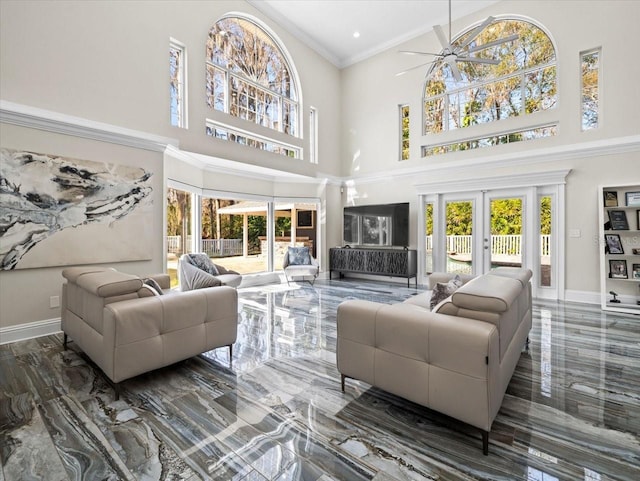 living room with ornamental molding, french doors, ceiling fan, and a high ceiling