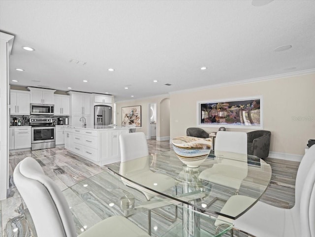 dining space with crown molding, sink, and a textured ceiling