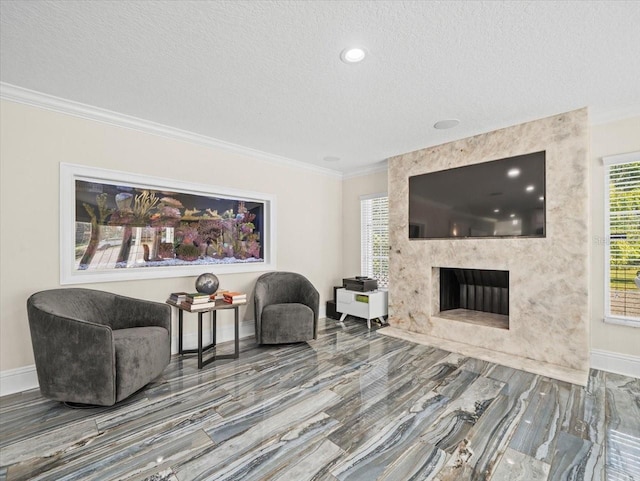 sitting room with crown molding, a high end fireplace, and a textured ceiling