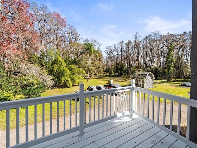 wooden terrace with a storage unit and a yard