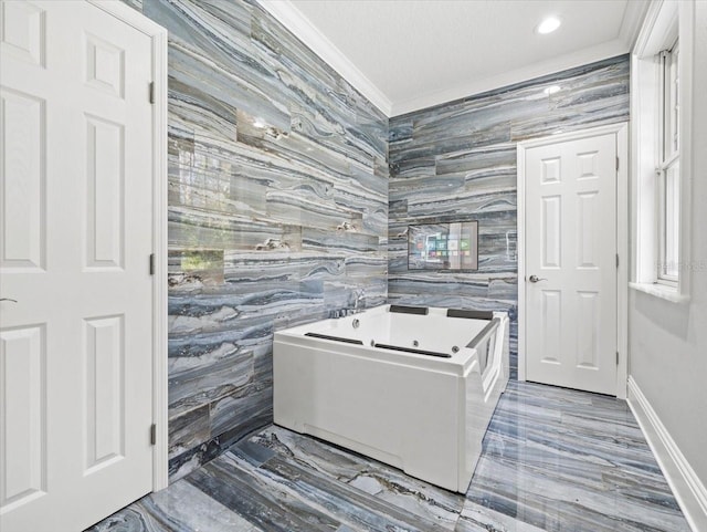 bathroom with ornamental molding, a bathing tub, and tile walls