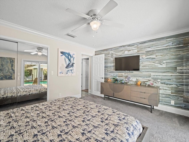 carpeted bedroom featuring ceiling fan, ornamental molding, and a textured ceiling