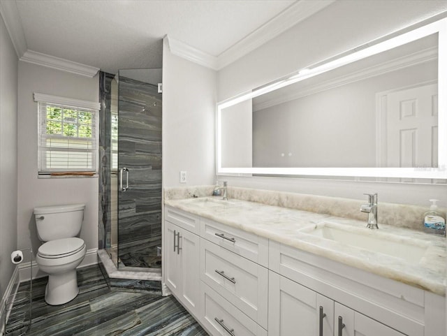 bathroom with a shower with door, crown molding, vanity, and toilet