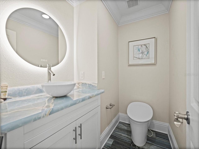 bathroom featuring ornamental molding, toilet, wood-type flooring, and vanity