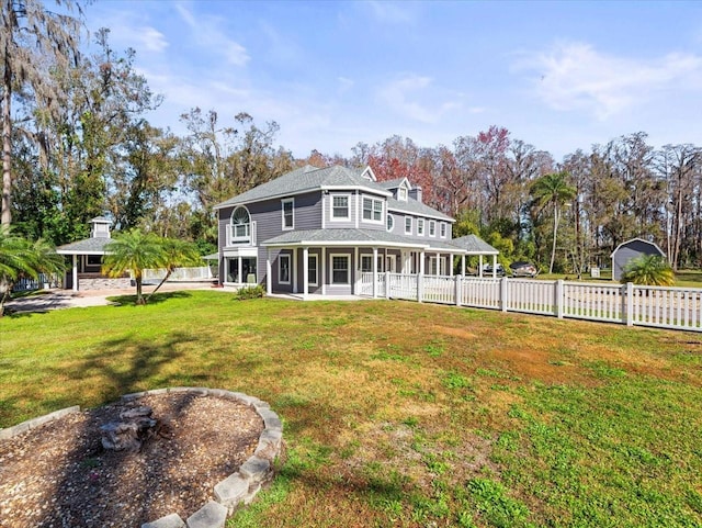 back of property with covered porch and a lawn