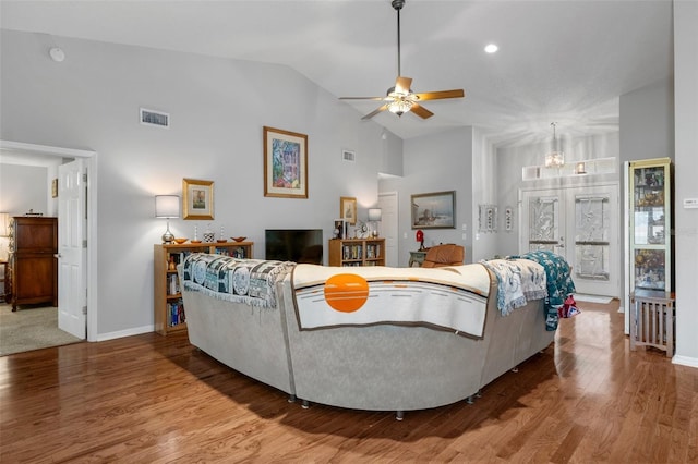 living room with hardwood / wood-style flooring, ceiling fan, and high vaulted ceiling