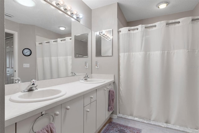 bathroom featuring vanity, tile patterned flooring, and a textured ceiling