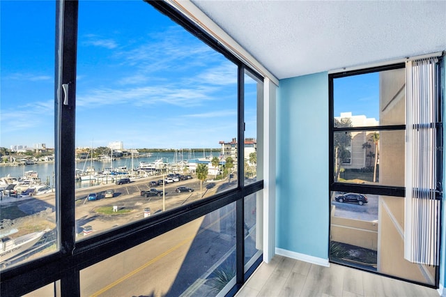 interior space featuring a water view, hardwood / wood-style floors, and a textured ceiling