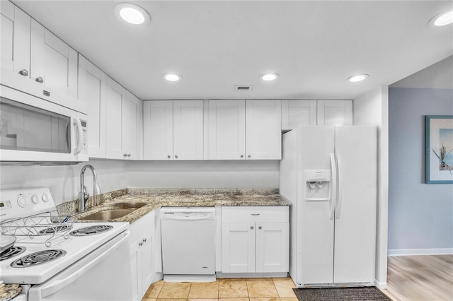 kitchen with sink, white cabinets, white appliances, and dark stone counters