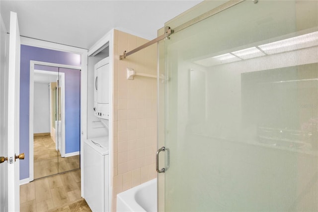 bathroom with wood-type flooring and stacked washing maching and dryer