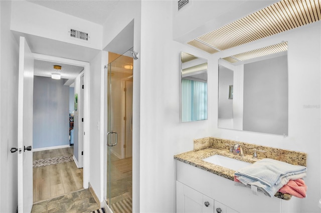 bathroom with vanity and a shower with door