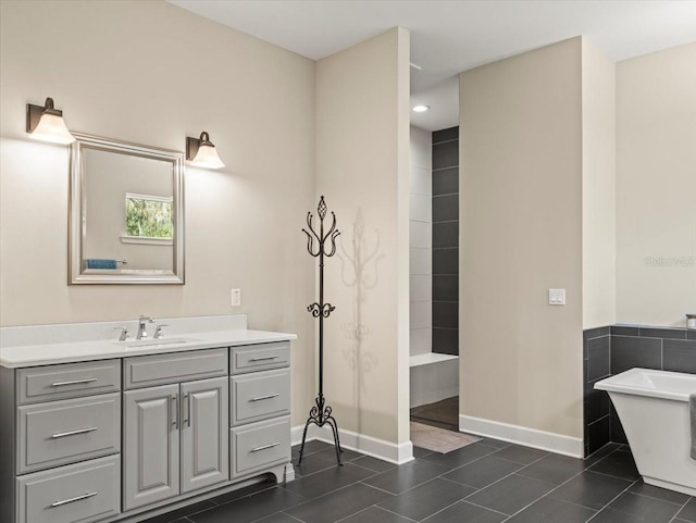 bathroom with tile patterned floors, a bathing tub, and vanity