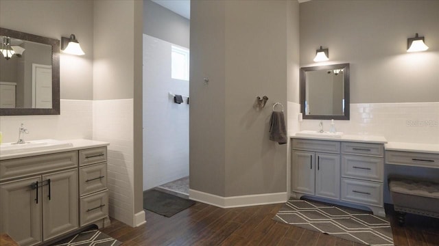 bathroom with wood-type flooring, tile walls, and vanity