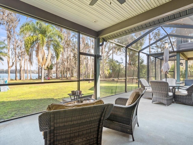 sunroom / solarium with a water view, plenty of natural light, and ceiling fan