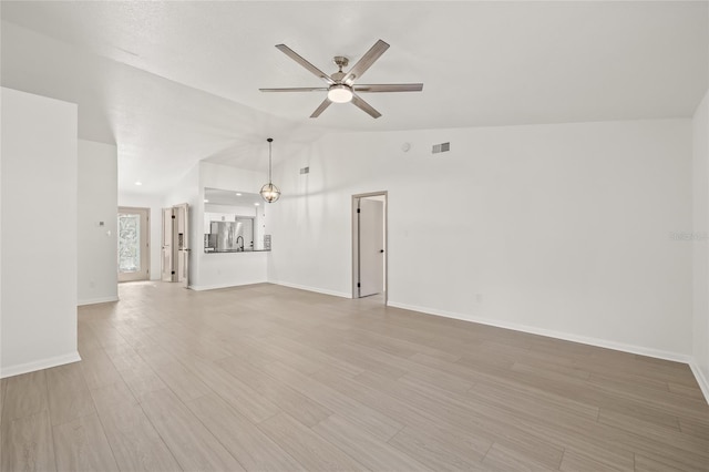 unfurnished living room with vaulted ceiling, ceiling fan, and light hardwood / wood-style flooring