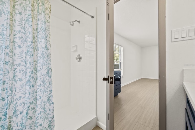 bathroom featuring hardwood / wood-style flooring and a tile shower