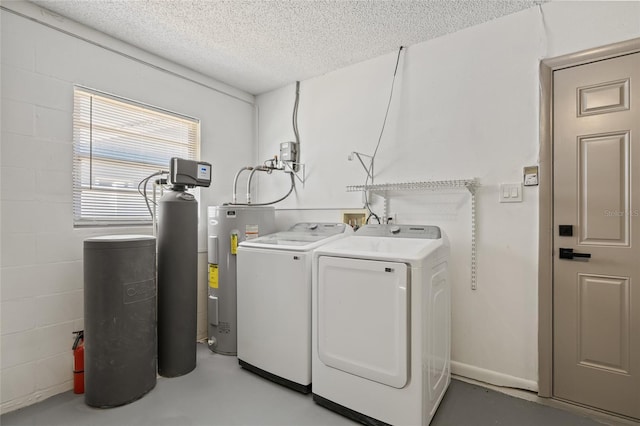 laundry room with washer and clothes dryer, water heater, and a textured ceiling