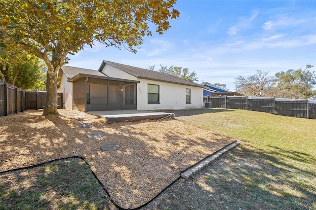 back of house featuring a lawn and a patio area