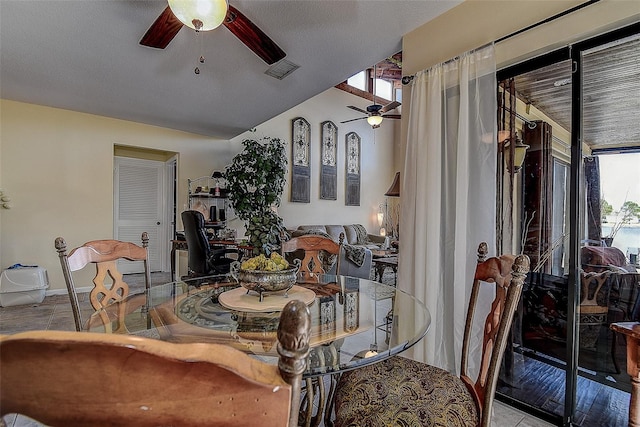 dining space with light tile patterned floors, a wealth of natural light, ceiling fan, and vaulted ceiling