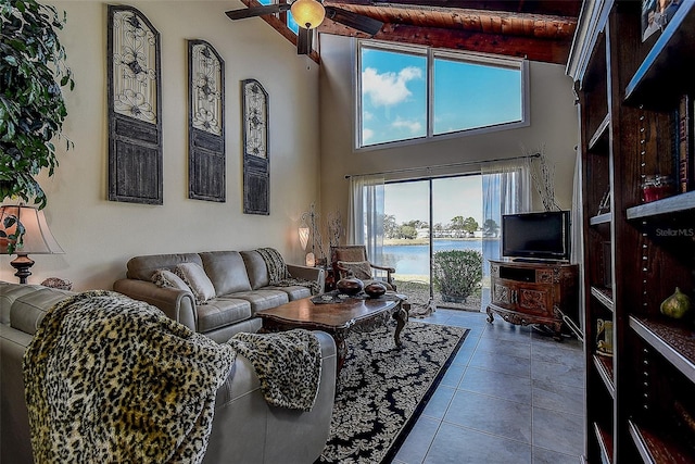 living room with ceiling fan, tile patterned flooring, and a towering ceiling