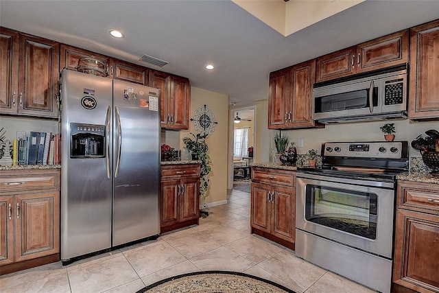 kitchen with light stone counters, appliances with stainless steel finishes, and light tile patterned flooring