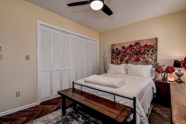 bedroom featuring dark parquet flooring, ceiling fan, and a closet