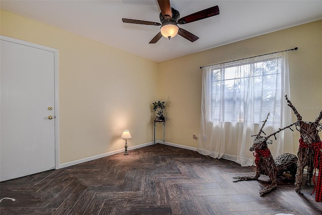 spare room featuring dark parquet floors and ceiling fan